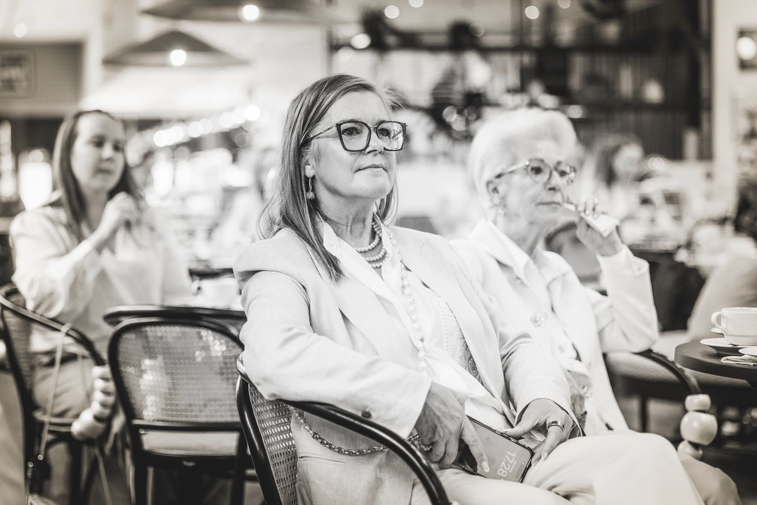 Mustavalkoinen kuva keskittyneistä kuulijoista